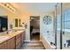 Bathroom featuring double sinks with granite counters and wood cabinets at 6322 Highledge St, North Las Vegas, NV 89081