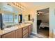 Bathroom featuring double sinks with granite counters and wood cabinets at 6322 Highledge St, North Las Vegas, NV 89081