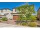 Charming two-story home featuring a brick driveway, two-car garage, and lovely landscaping at 6322 Highledge St, North Las Vegas, NV 89081