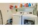 Functional laundry room with modern washer and dryer, with overhead shelving for cleaning supplies and storage at 6322 Highledge St, North Las Vegas, NV 89081