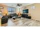 Cozy living room featuring plush seating, a ceiling fan, and bright natural light from the large windows at 6322 Highledge St, North Las Vegas, NV 89081