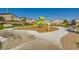 A well-maintained community playground with green play structure surrounded by grass and benches at 6322 Highledge St, North Las Vegas, NV 89081