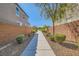 A sidewalk between two homes offers a charming passage framed by appealing exterior landscaping at 6322 Highledge St, North Las Vegas, NV 89081