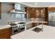 Kitchen featuring stainless steel appliances, white countertops, wood floors, wood cabinets, and a tile backsplash at 9101 Alta Dr # 1202, Las Vegas, NV 89145