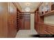 Spacious primary closet features custom wood shelving, cabinets and chandelier lighting at 9101 Alta Dr # 1202, Las Vegas, NV 89145