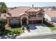 Two-story house with tile roof, three car garage, and landscaped yard at 8713 W Gilmore Ave, Las Vegas, NV 89129