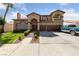 Two-story house with tile roof, three car garage and landscaped yard at 8713 W Gilmore Ave, Las Vegas, NV 89129