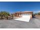 Lovely single-story home featuring a spacious driveway and desert landscaping, nestled under a clear blue sky at 1830 E Fuchsia St, Pahrump, NV 89048