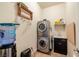 Functional laundry room with stacked washer/dryer, utility sink, and storage solutions for efficient space utilization at 1830 E Fuchsia St, Pahrump, NV 89048