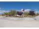 Landscaped yard with gravel and plants, showcasing an American flag and street sign at 1830 E Fuchsia St, Pahrump, NV 89048