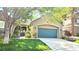 Exterior view of the front of the home, with lawn, driveway, blue garage door, and mature tree at 9809 Miss Peach Ave, Las Vegas, NV 89145