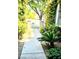 View of the front walkway leading to the white gate and front door, surrounded by lush greenery at 9809 Miss Peach Ave, Las Vegas, NV 89145