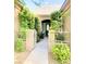 Home entrance featuring a gated walkway lined with lush greenery and decorative stone at 9809 Miss Peach Ave, Las Vegas, NV 89145