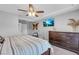 Bedroom features a ceiling fan, television, and a woven wall hanging at 7135 Polaris Ave, Las Vegas, NV 89118