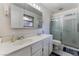 Bright bathroom featuring a double sink vanity, large mirror, and a glass-enclosed shower at 2240 Horse Creek Cir, Henderson, NV 89014