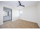 Cozy bedroom with neutral carpet, ceiling fan, and attached bathroom for convenience at 510 Duvet Ct, Henderson, NV 89012