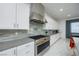 Modern kitchen featuring stainless steel appliances, white cabinetry, and tile backsplash at 510 Duvet Ct, Henderson, NV 89012