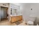 Well-lit bathroom with a double vanity, a toilet, and light wood-look flooring at 1430 Red Rock Dr, Pahrump, NV 89048