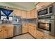 Close-up of a kitchen featuring wooden cabinetry, stainless steel appliances, and granite countertops at 1430 Red Rock Dr, Pahrump, NV 89048