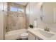 Bright bathroom featuring tile shower-tub combination and vanity with decorative mirror at 10315 Premia Pl, Las Vegas, NV 89135