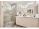 Bathroom featuring double sinks, modern vanity and stone-finished shower at 10315 Premia Pl, Las Vegas, NV 89135