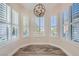 Charming dining area features multiple windows with shutters and an eye-catching orb chandelier at 10315 Premia Pl, Las Vegas, NV 89135