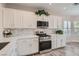 Modern kitchen featuring white cabinets, stainless steel appliances, and quartz countertops at 10315 Premia Pl, Las Vegas, NV 89135