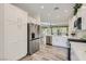 Bright kitchen with stainless steel appliances, white cabinets and countertops, and wood floors at 10315 Premia Pl, Las Vegas, NV 89135