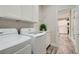 Well-lit laundry room with white cabinets, countertop, and modern appliances at 10315 Premia Pl, Las Vegas, NV 89135