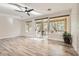Spacious living room with hardwood flooring, large windows and a ceiling fan at 10315 Premia Pl, Las Vegas, NV 89135