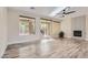 Open living room featuring a ceiling fan, fireplace, sliding glass doors, and natural light at 10315 Premia Pl, Las Vegas, NV 89135