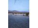 Gravel backyard with distant mountain views and desert landscape at dusk at 4780 Horizon Ave, Pahrump, NV 89060