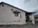 Angle view of a home with siding, boarded up windows, and a satellite dish at 4780 Horizon Ave, Pahrump, NV 89060