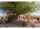 Home's backyard featuring covered patios, desert landscaping, and mature shade trees at 1214 Country Club Dr, Laughlin, NV 89029