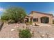 Desert-landscaped backyard featuring covered patios, mature trees, and decorative rock features at 1214 Country Club Dr, Laughlin, NV 89029