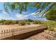 Backyard view showcasing the wrought iron fence, mature trees, and desert landscape at 1214 Country Club Dr, Laughlin, NV 89029