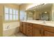 Bathroom featuring double sinks, large mirror and bathtub at 1214 Country Club Dr, Laughlin, NV 89029