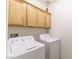 Bright laundry room featuring a stacked washer and dryer, and upper wood cabinetry for storage at 1214 Country Club Dr, Laughlin, NV 89029