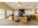 Bright living room featuring a stacked stone fireplace, ceiling fan and many windows at 1214 Country Club Dr, Laughlin, NV 89029