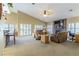 Bright living room featuring a stacked stone fireplace, ceiling fan and many windows at 1214 Country Club Dr, Laughlin, NV 89029