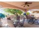 Covered patio area with ceiling fan, stylish outdoor furniture, and views of the landscaped backyard at 1214 Country Club Dr, Laughlin, NV 89029
