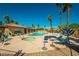 Community pool area with a hot tub, lounge chairs, palm trees, and clear blue skies at 1214 Country Club Dr, Laughlin, NV 89029