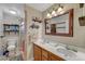 Bathroom featuring double sinks, framed mirror, wood cabinets, and a glass-enclosed shower at 2213 W Oakey Blvd, Las Vegas, NV 89102