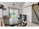 Dining area featuring tile flooring, a sliding glass door to the backyard, and a rustic sliding barn door at 2213 W Oakey Blvd, Las Vegas, NV 89102