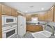 Kitchen with light wood cabinets, granite counters, and white appliances at 31 E Agate Ave # 205, Las Vegas, NV 89123