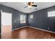 Bedroom with wood floors, a ceiling fan, two windows and blue-grey painted walls at 3665 Bella Legato Ave, North Las Vegas, NV 89081