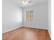 A minimalist bedroom with hardwood flooring, a ceiling fan, and a sunlit window at 3665 Bella Legato Ave, North Las Vegas, NV 89081