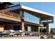 Modern home exterior with clean lines, large windows, and an outdoor lounge area overlooking desert landscaping at 685 Dragon Peak Dr, Henderson, NV 89012