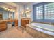 Bright bathroom with a soaking tub, dual sinks and a vanity area with carpeted floors at 48 Panorama Crest Ave, Las Vegas, NV 89135