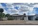 Cozy single-story home featuring desert landscaping and a private, gated front yard under a partly cloudy sky at 1828 Hassett Ave, Las Vegas, NV 89104